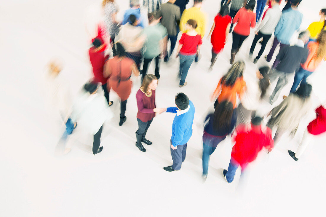 Business people handshaking in crowd