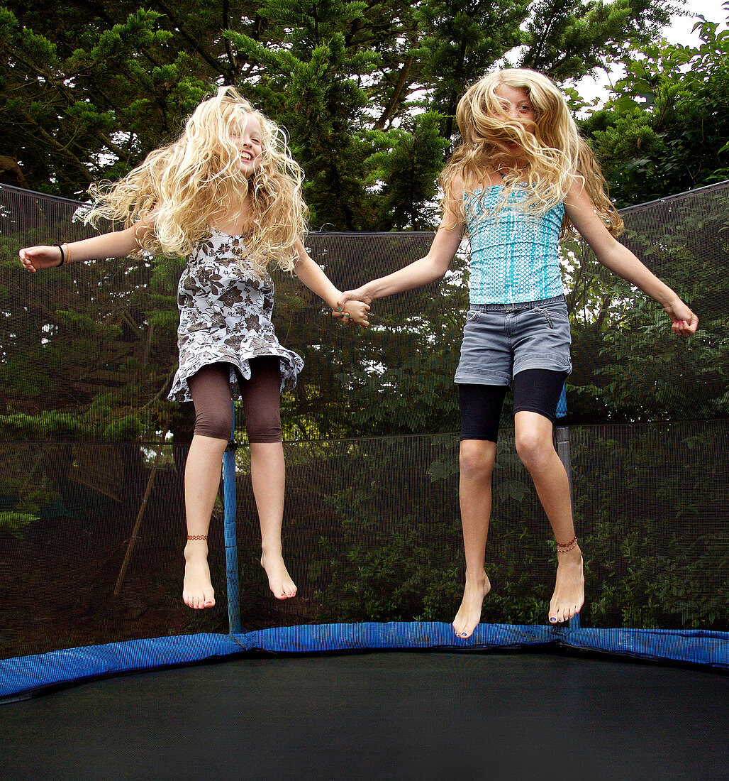 Girls jumping on trampoline outdoors