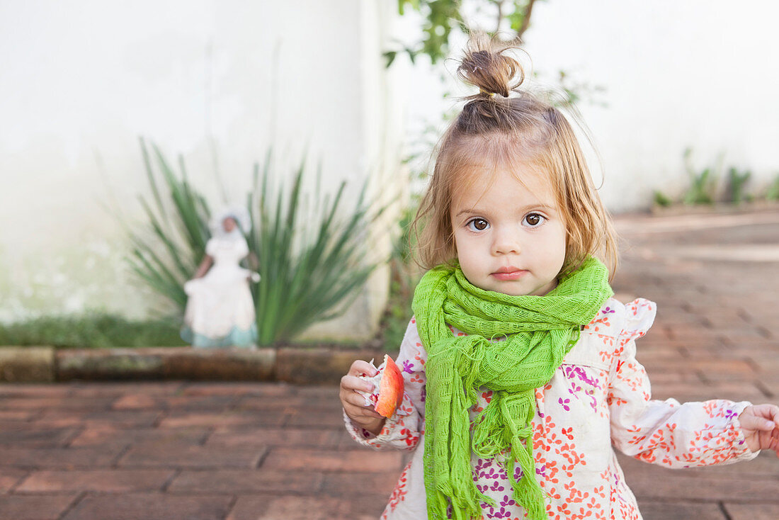 Baby girl eating fruit outdoors