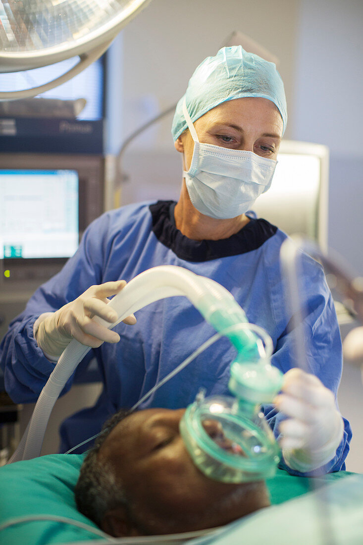 Anaesthesiologist holding oxygen mask