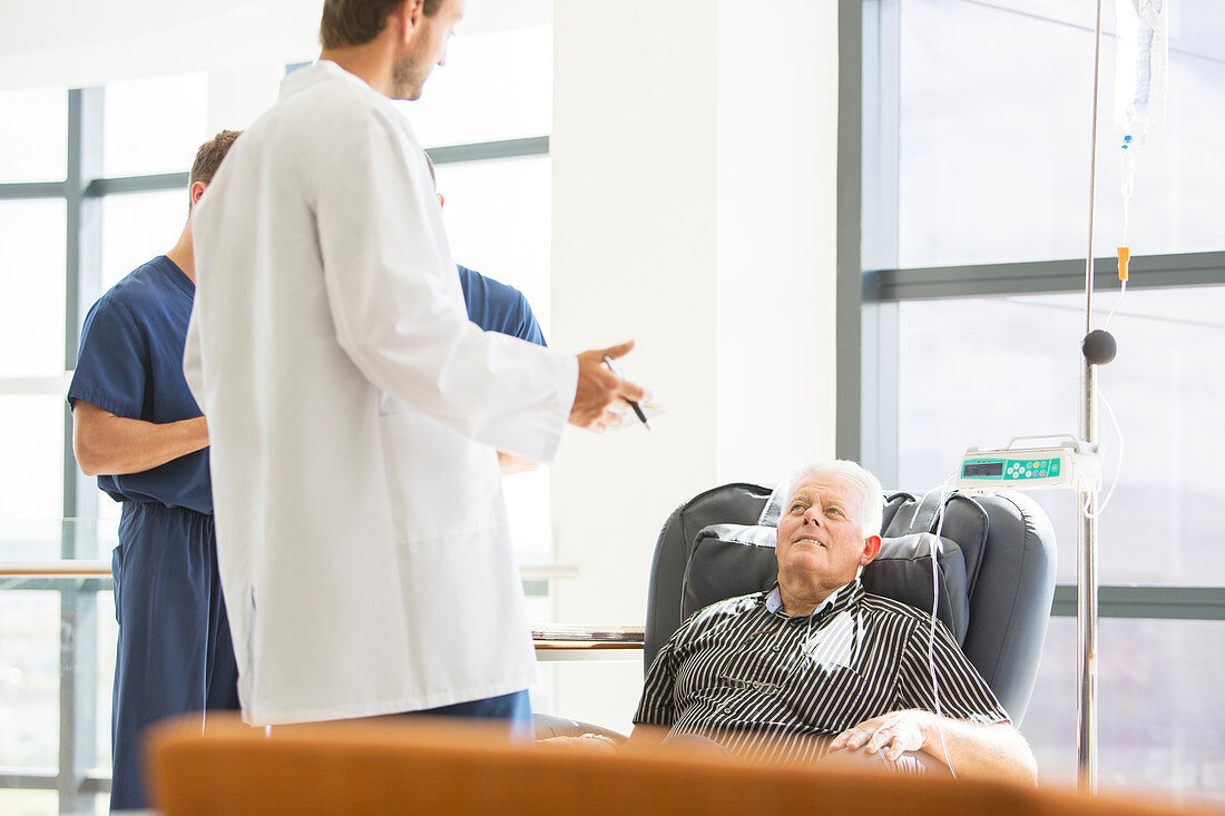 Two doctors talking to senior patient
