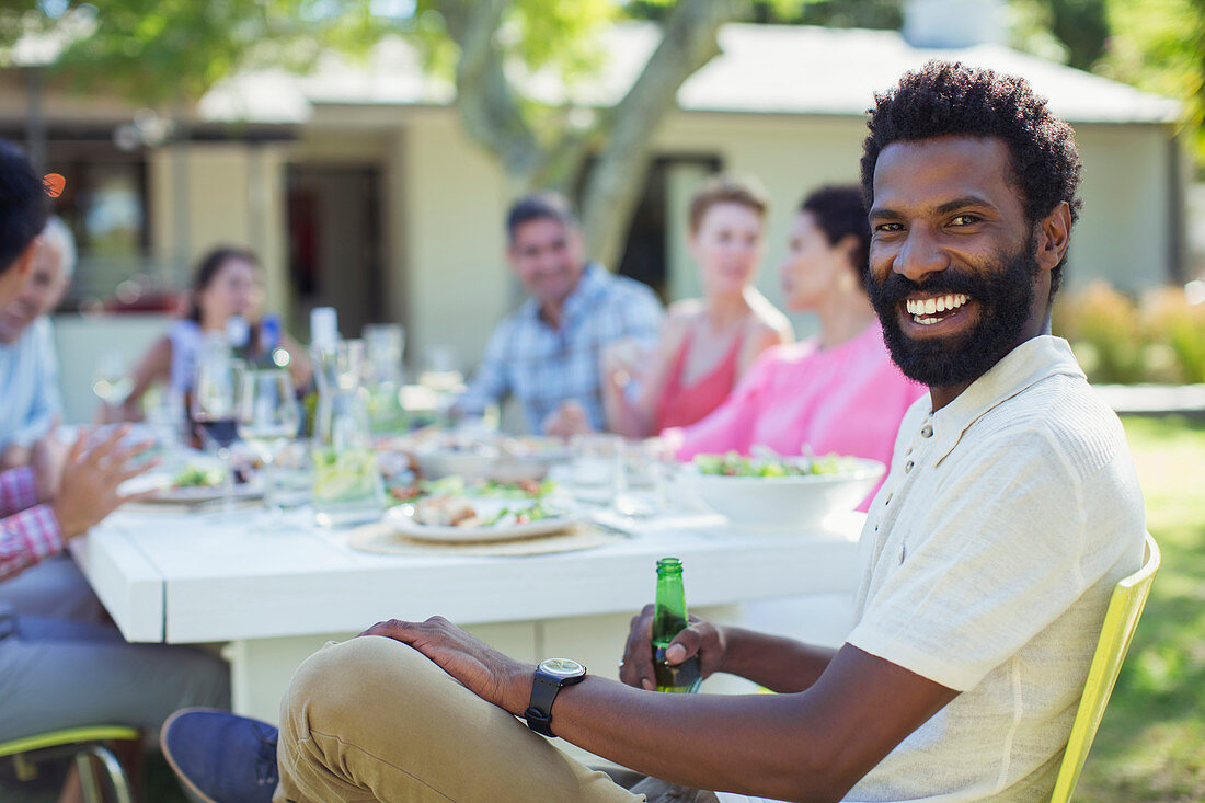 Man smiling at table outdoors