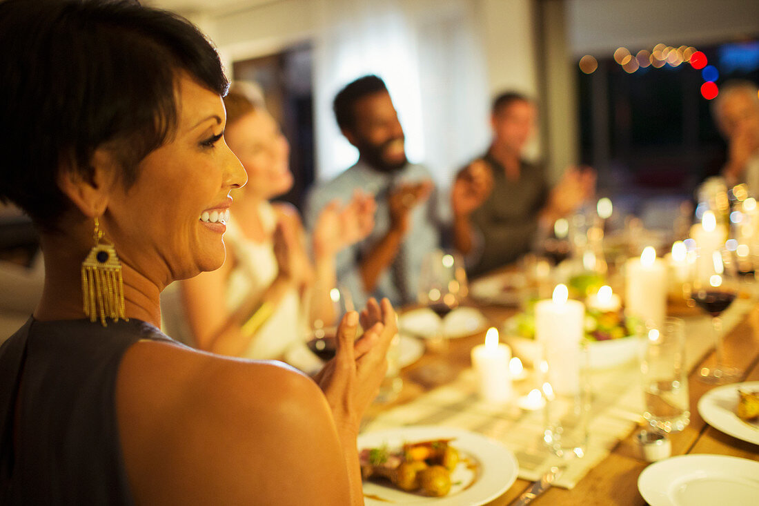 Friends applauding at dinner party