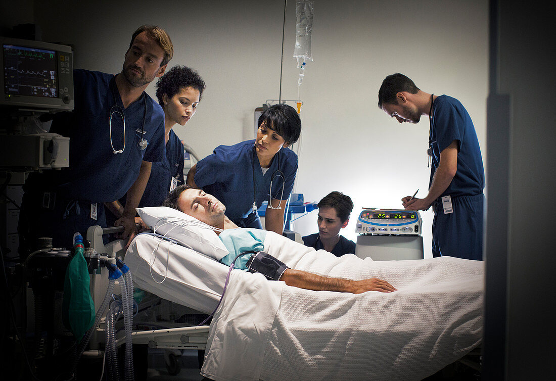Group of doctors caring for patient ward