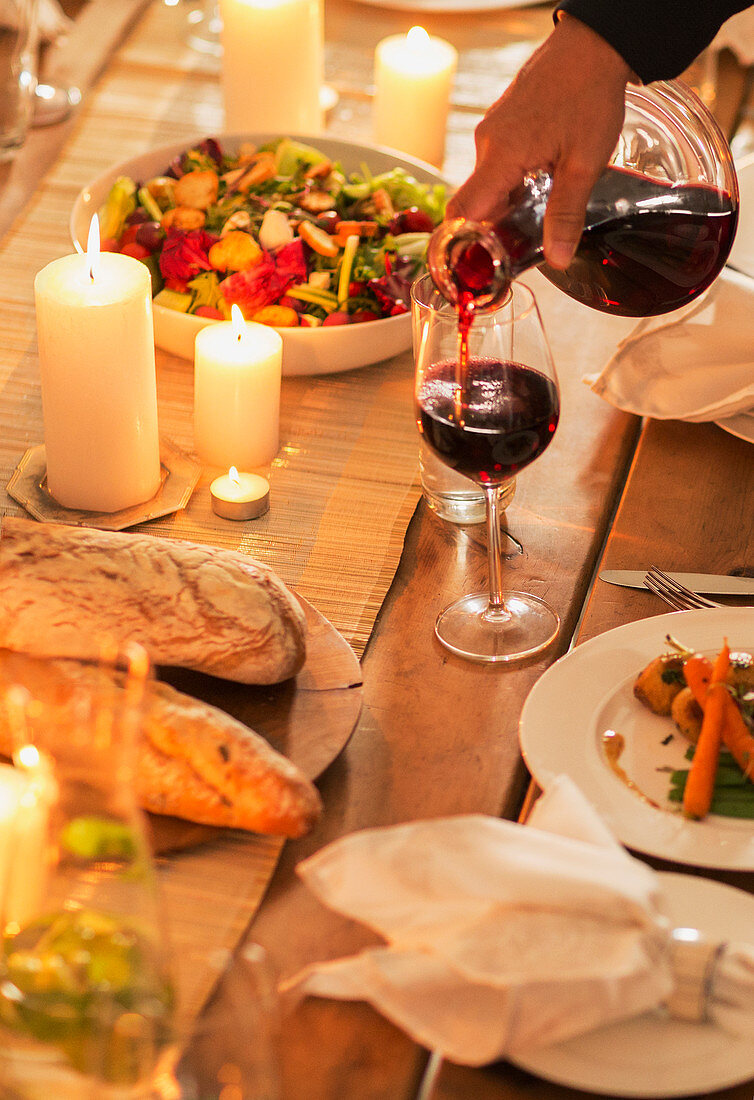 Woman pouring wine at dinner party