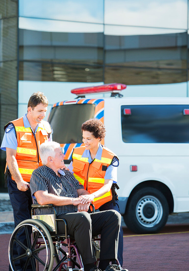 Paramedics greeting patient in wheelchair