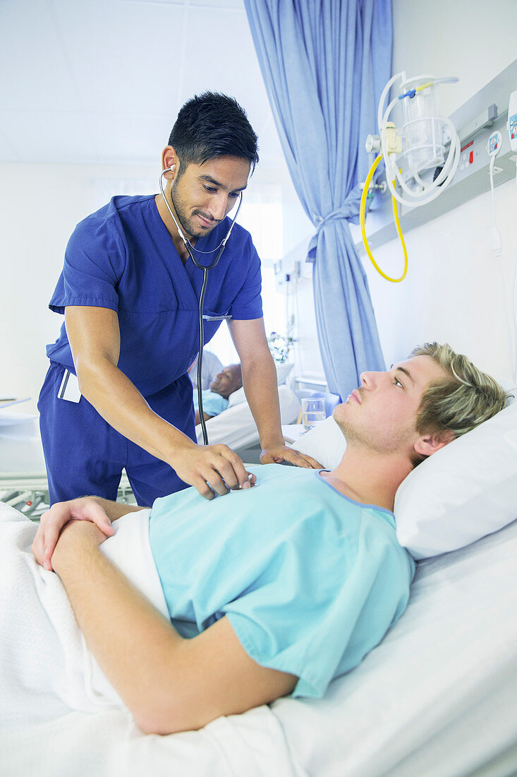 Nurse examining patient in hospital room