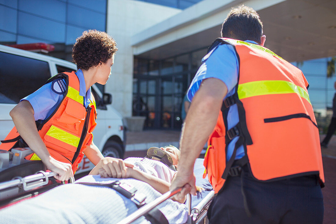 Paramedics wheeling patient parking lot