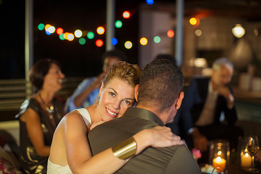 Couple hugging at party