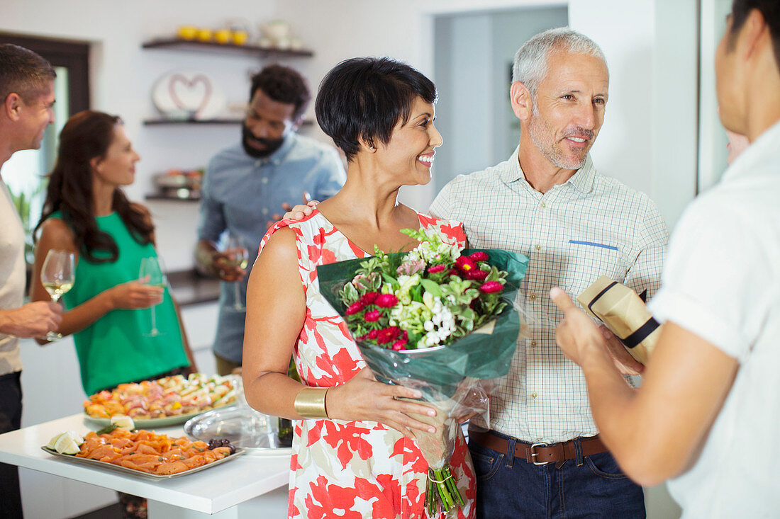 Couple bringing flowers to party