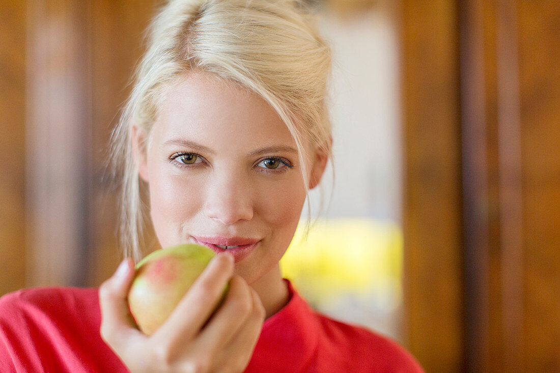 Woman eating apple indoors