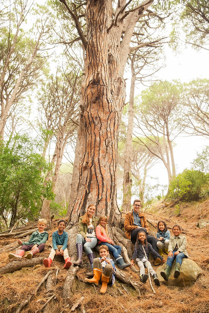 Students and teachers sitting on tree