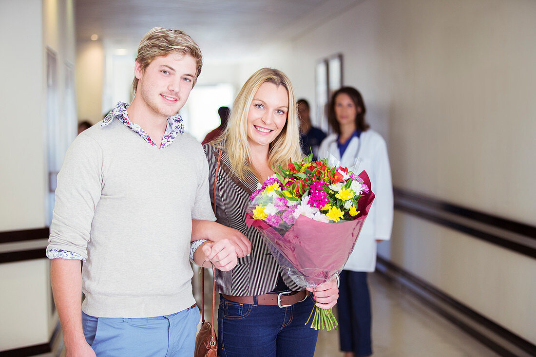Couple carrying bouquet of flowers