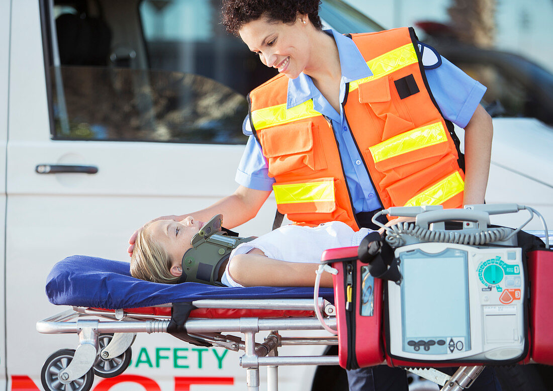 Paramedic examining patient on stretcher