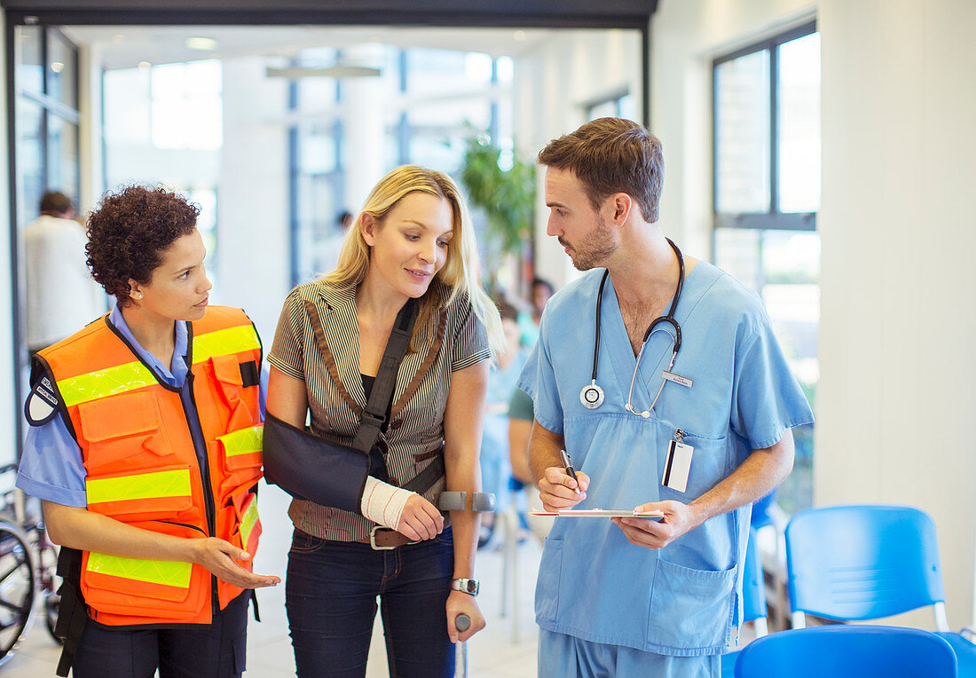 Nurse and paramedic talking to patient