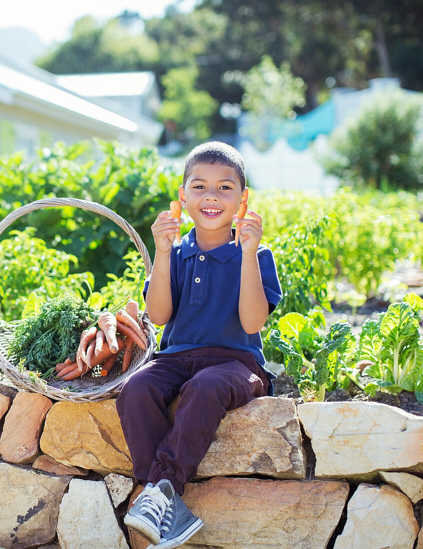 Boy with basket of produce in garden