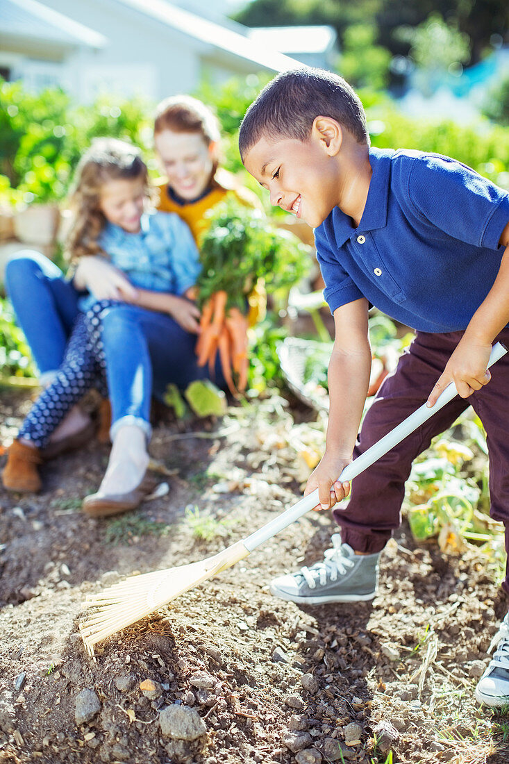 Boy turning over soil in garden