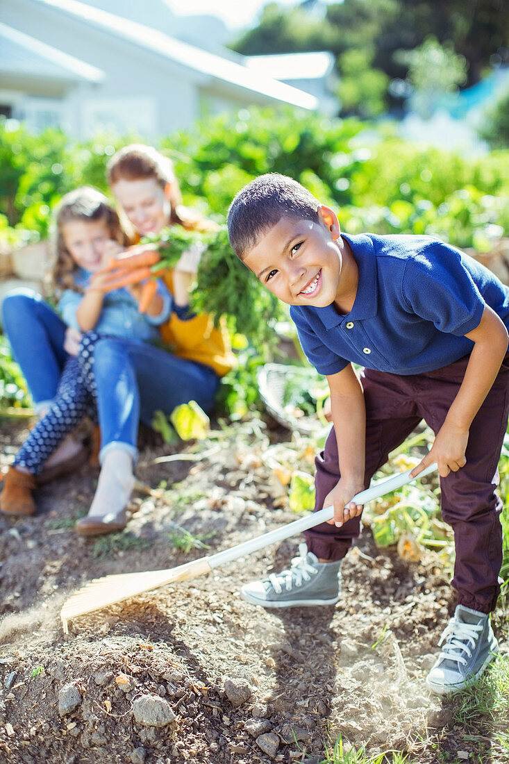 Boy turning over dirt in garden