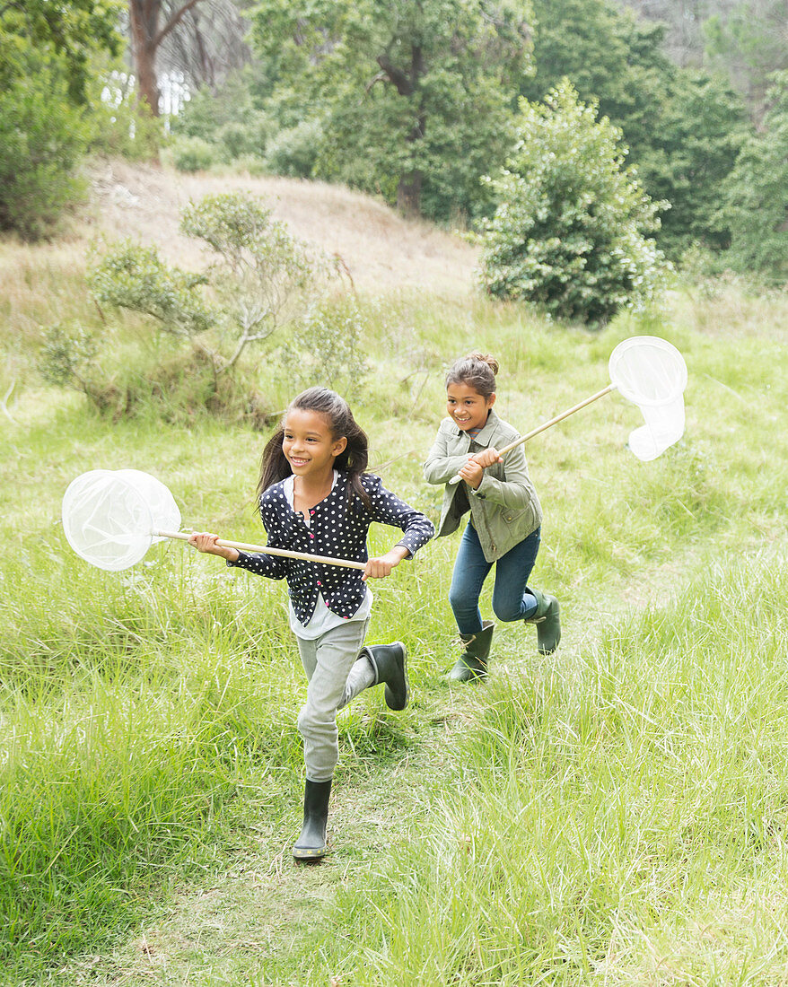 Girls using butterfly nets in field