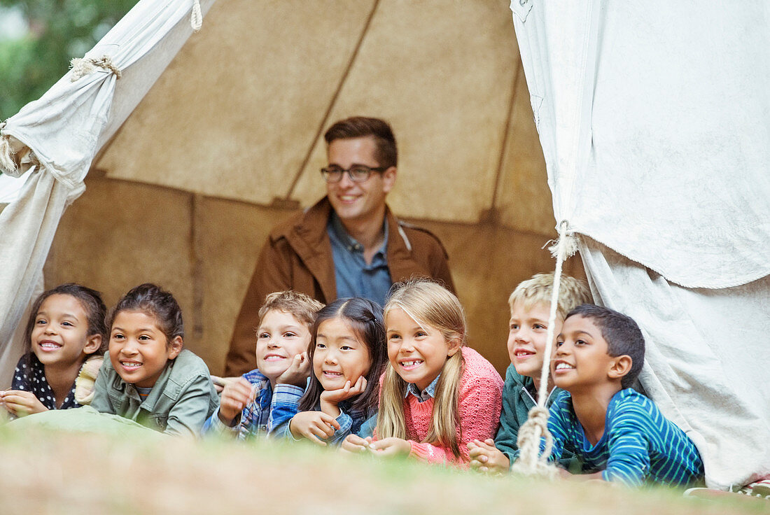 Students and teacher smiling in tent