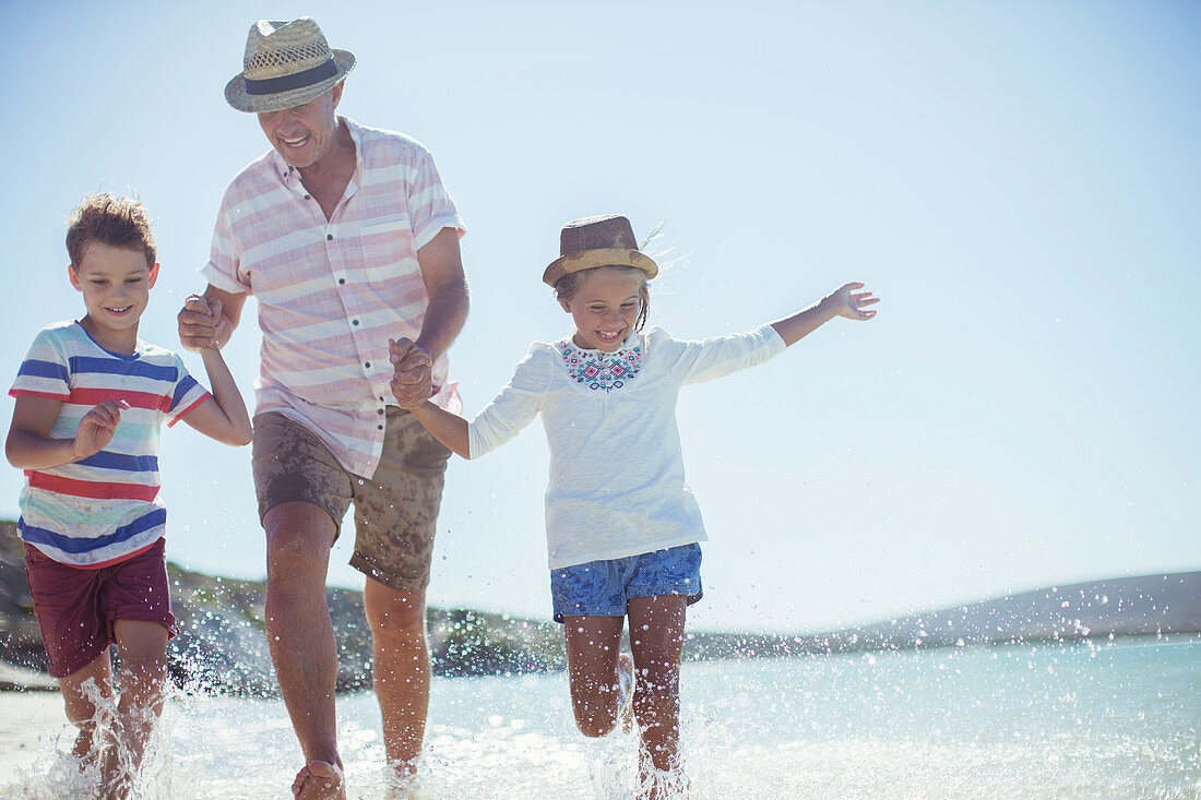 Family running in water on beach