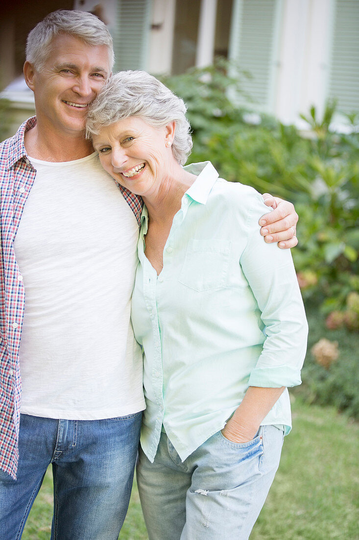 Older couple hugging outdoors