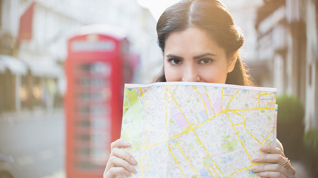 Woman holding map on city street