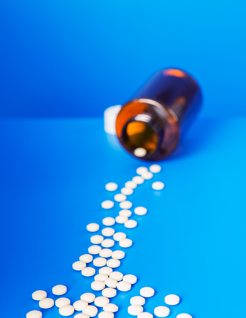 Prescription pills spilling from bottle