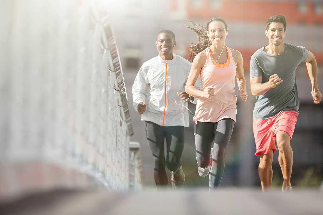 Friends running through city streets