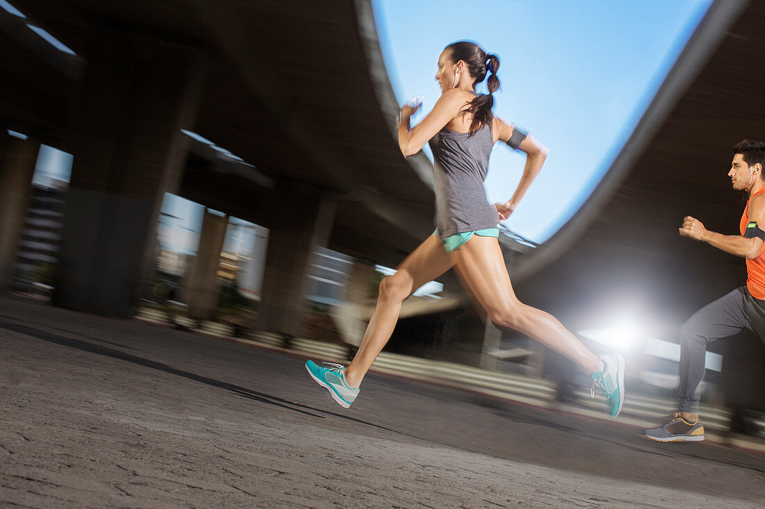 Couple running through city streets