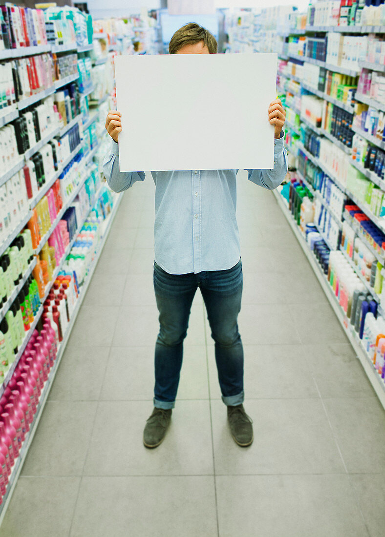 Man holding blank card aisle