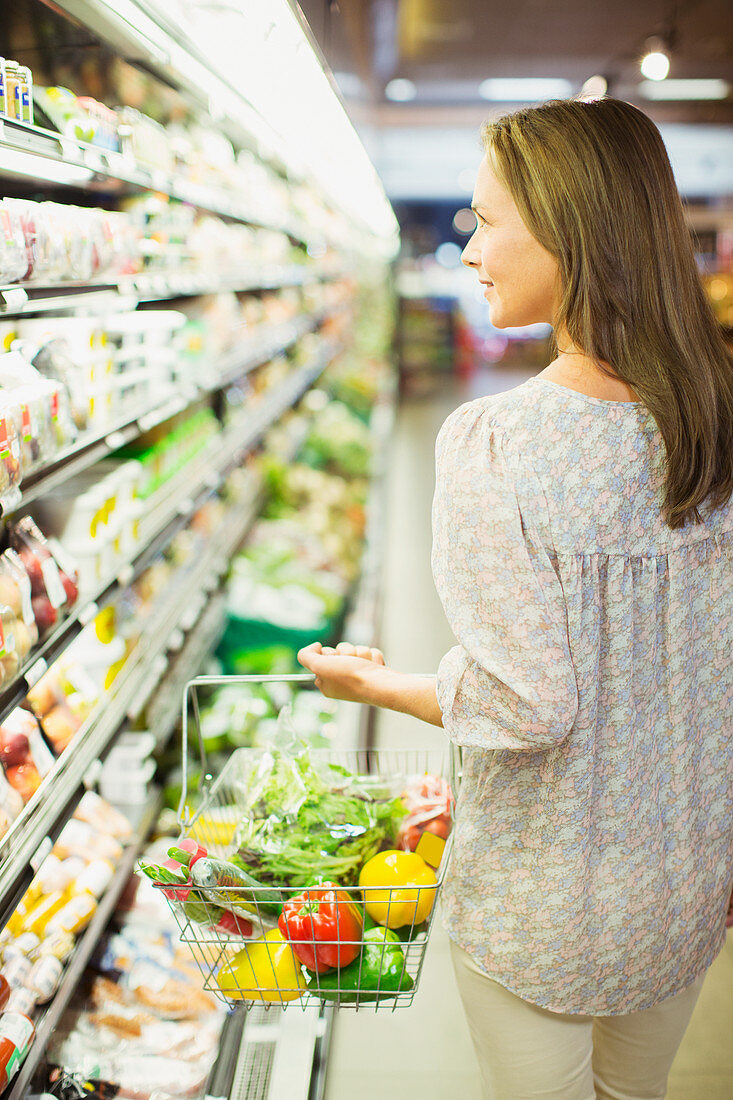 Woman carrying full shopping basket