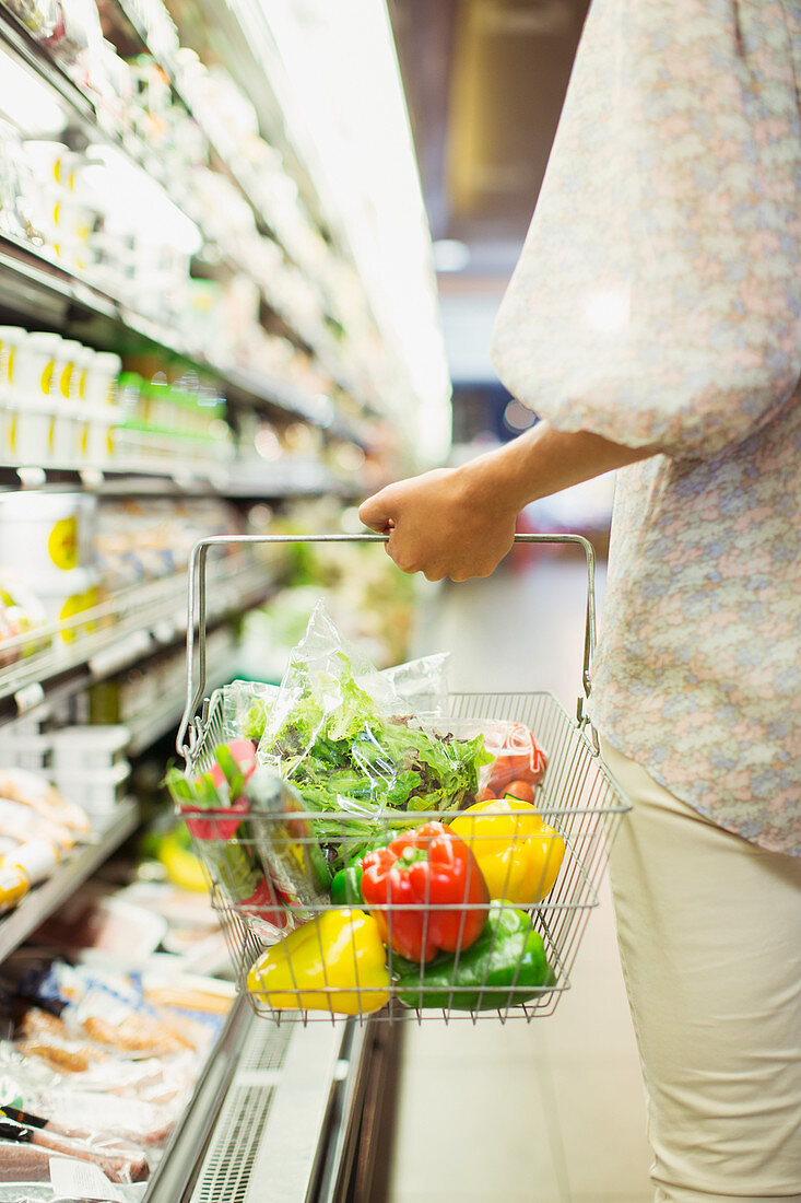 Woman carrying full shopping basket