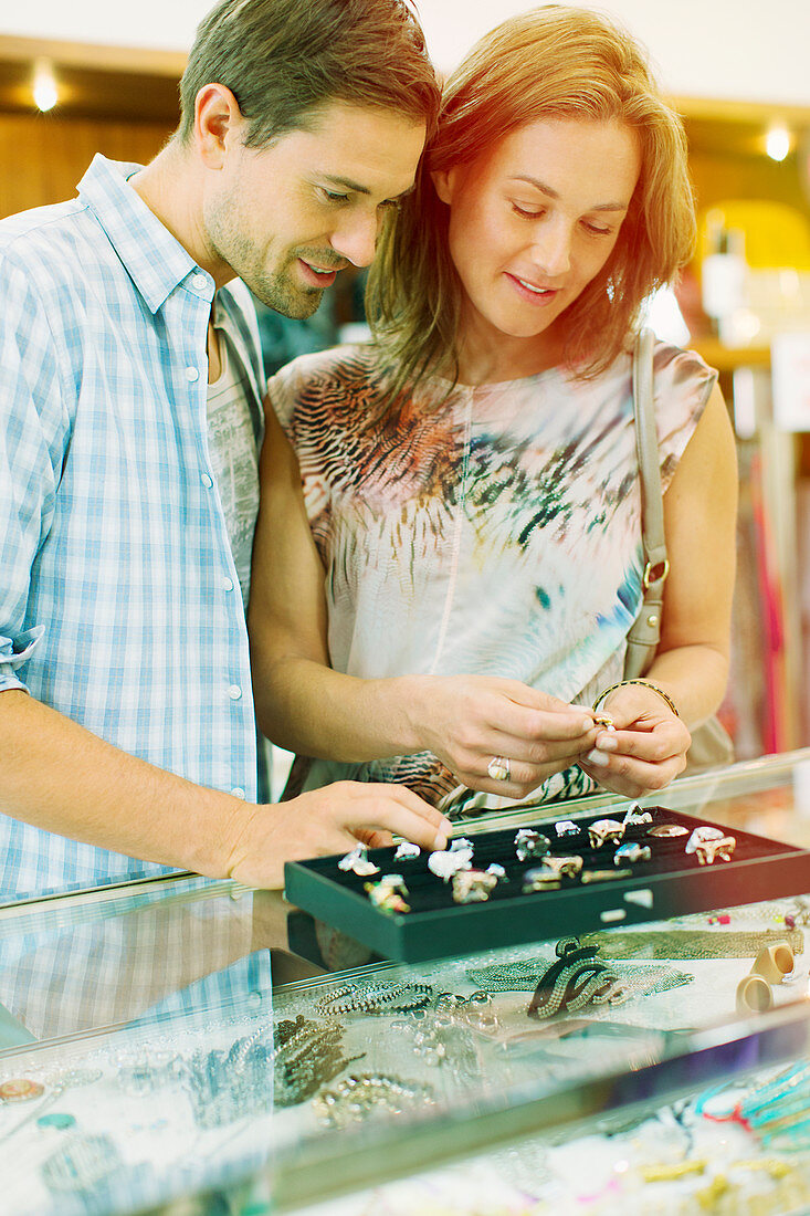 Couple examining jewellery in store