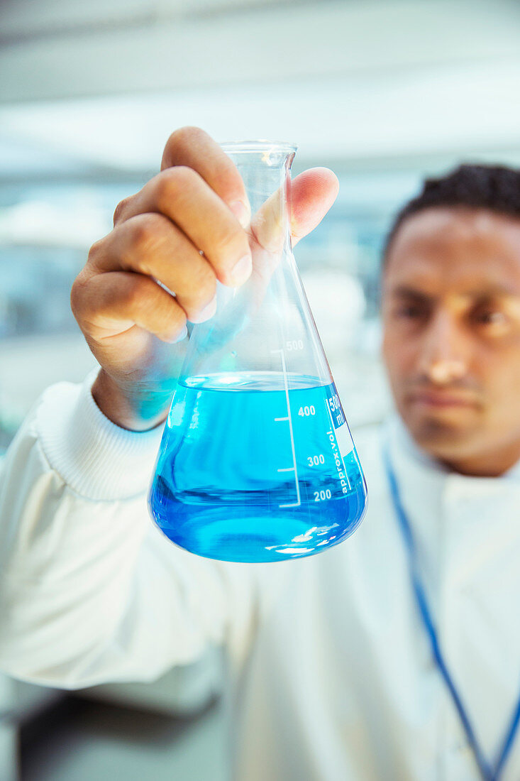 Scientist examining sample in beaker