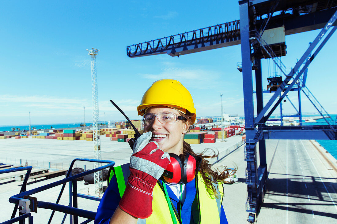 Worker using walkie-talkie at waterfront