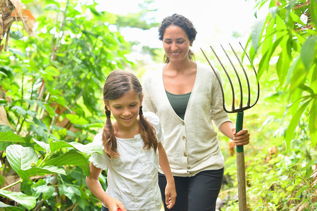 Girl and woman with gardening fork