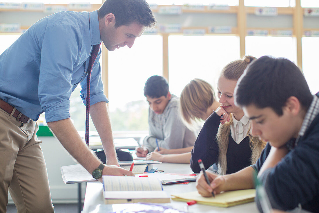 Teacher helping his students in classroom