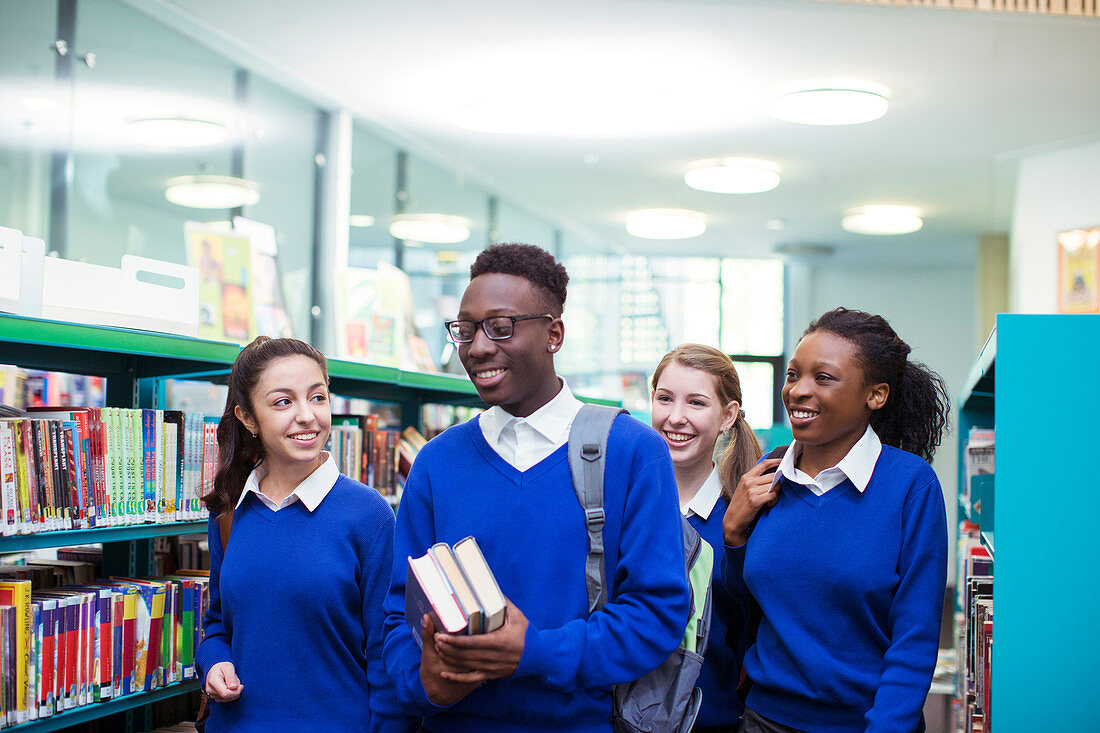 Cheerful students walking through library