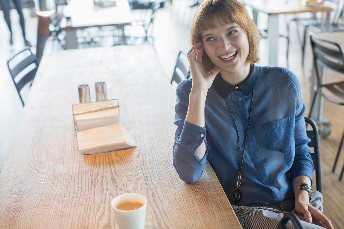 Businesswoman laughing at cafeteria table