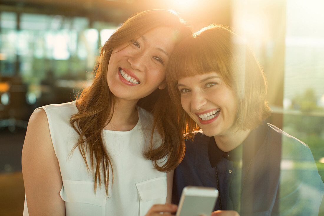 Businesswomen using cell phone in office