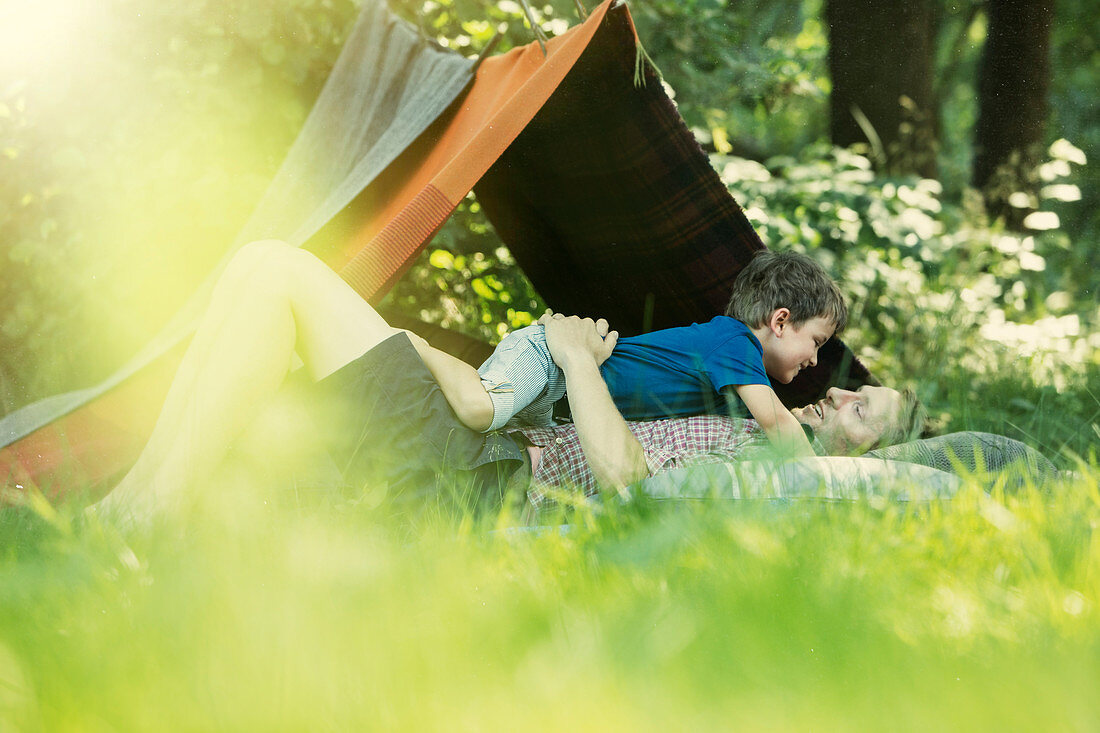 Father and son laying in grass