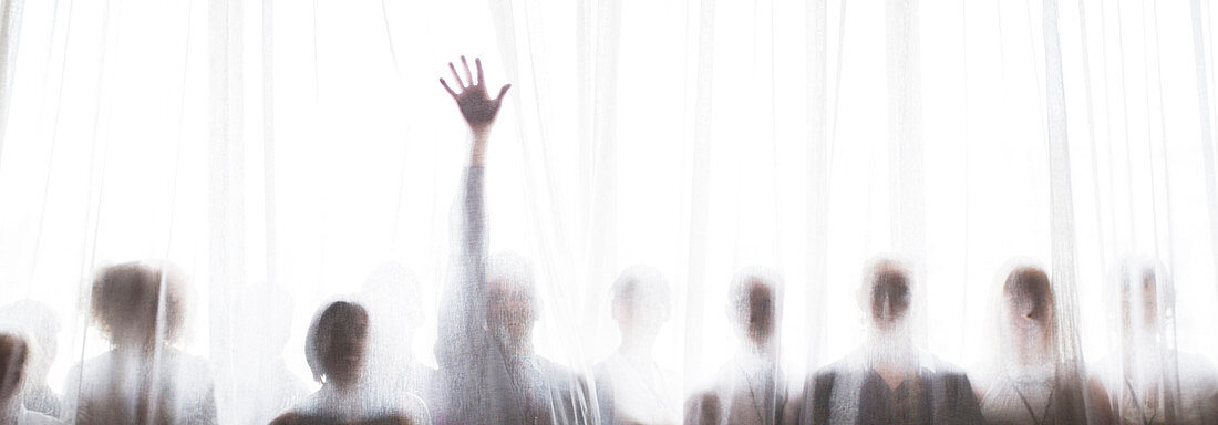Silhouette of people raising hands