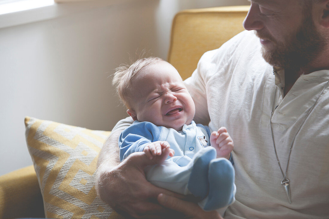 Father holding crying baby
