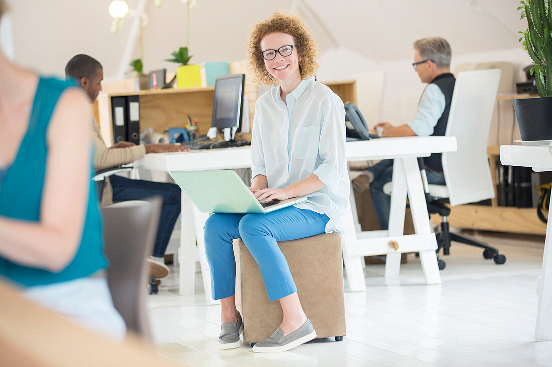 Portrait of woman holding laptop