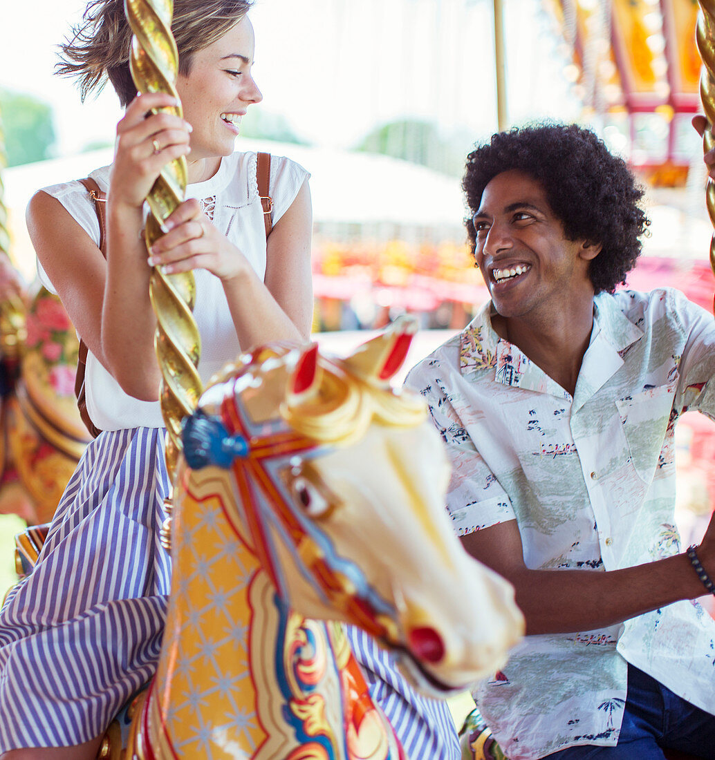 Young multiracial couple on carousel