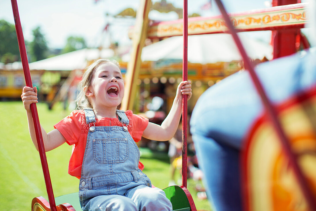 Cheerful girl laughing on carousel