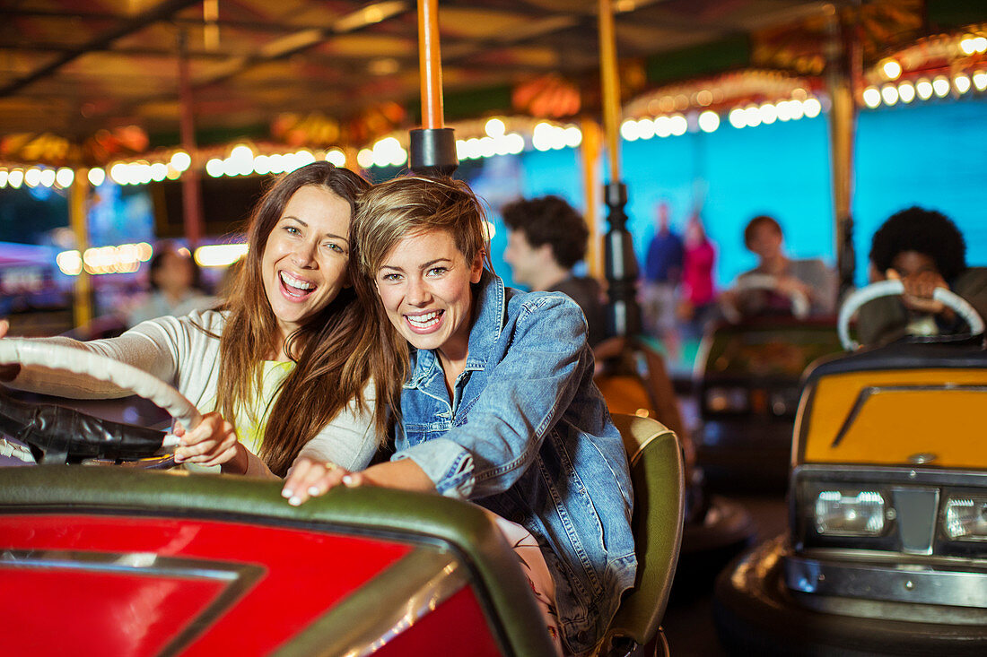 Two cheerful women on bumper car ride