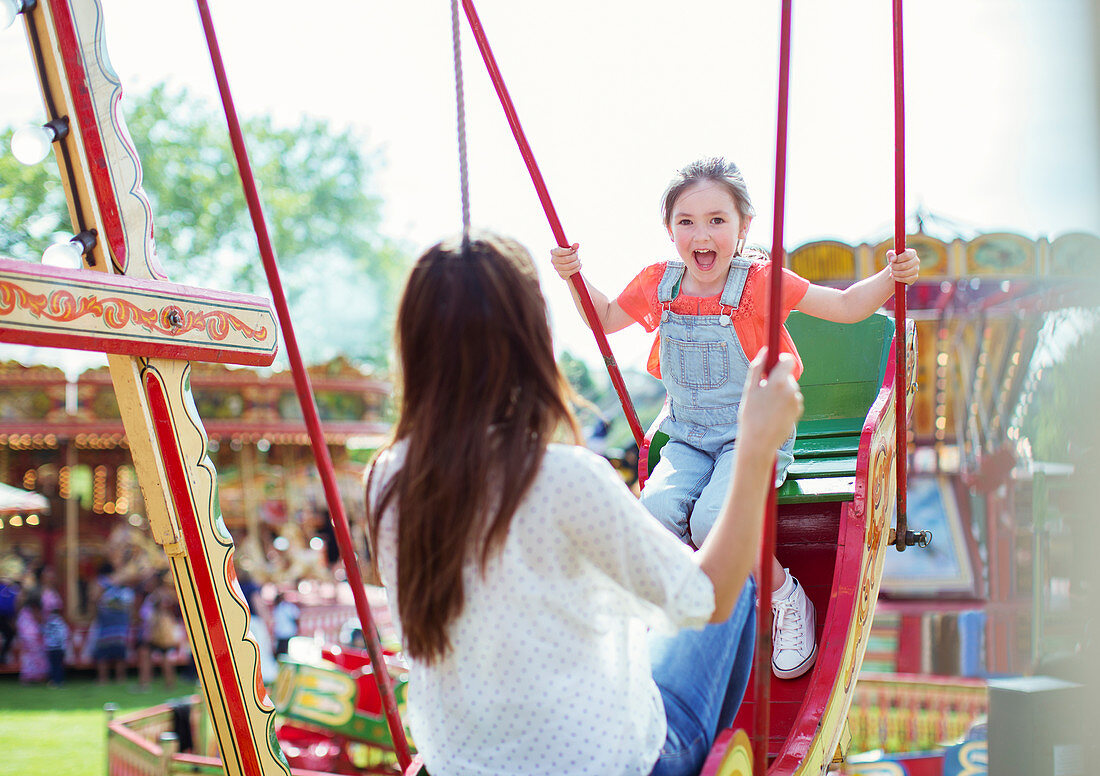 Mother and daughter playing on swing