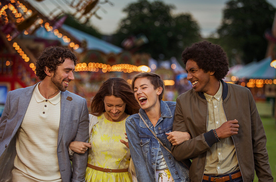 Two couples walking and laughing at dusk